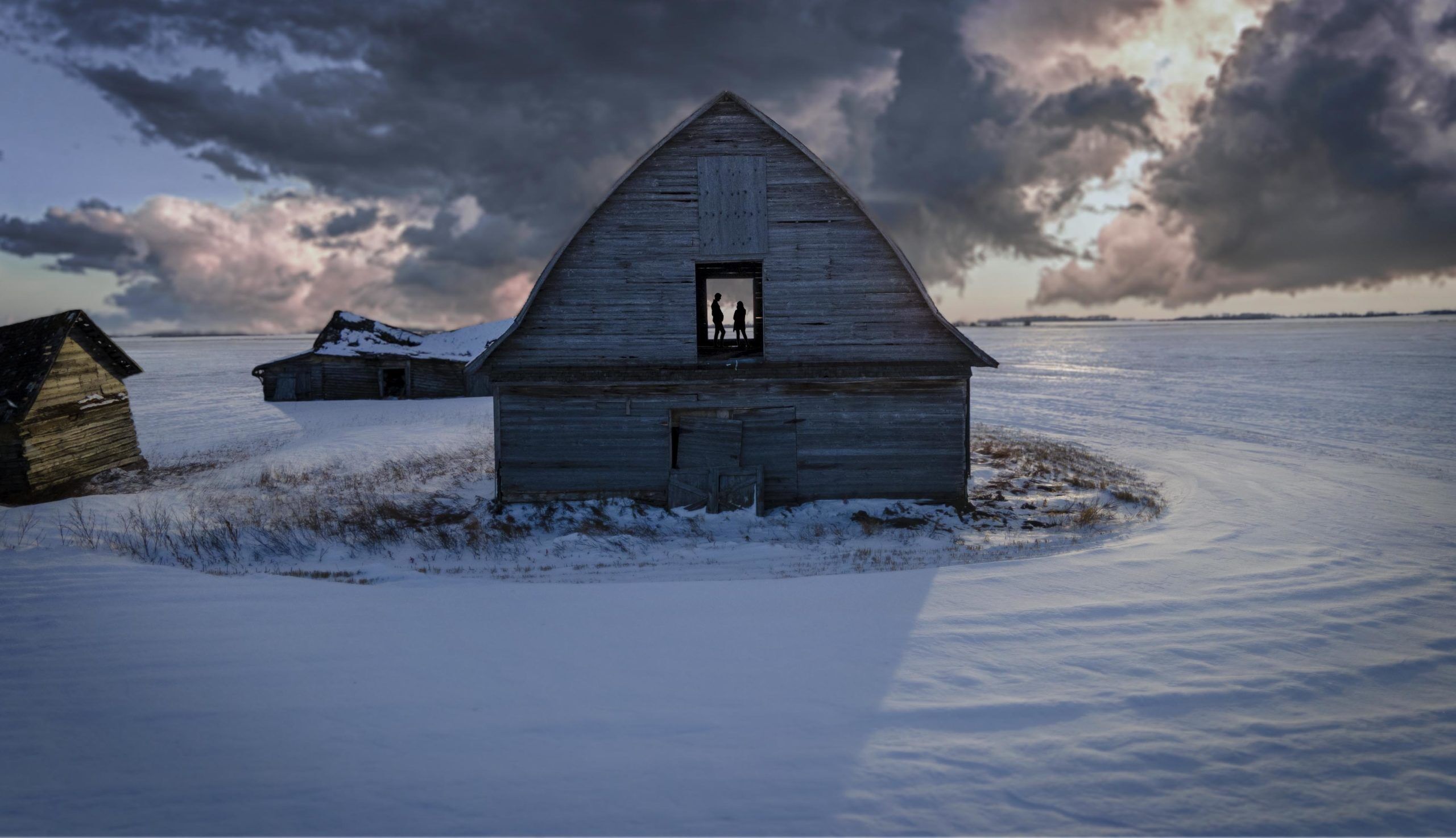 Two people enjoying the living sky of Saskatchewan in an Abandoned Barn.